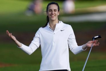 Caitlin Clark smiling with a putter on a golf course during a pro-am round